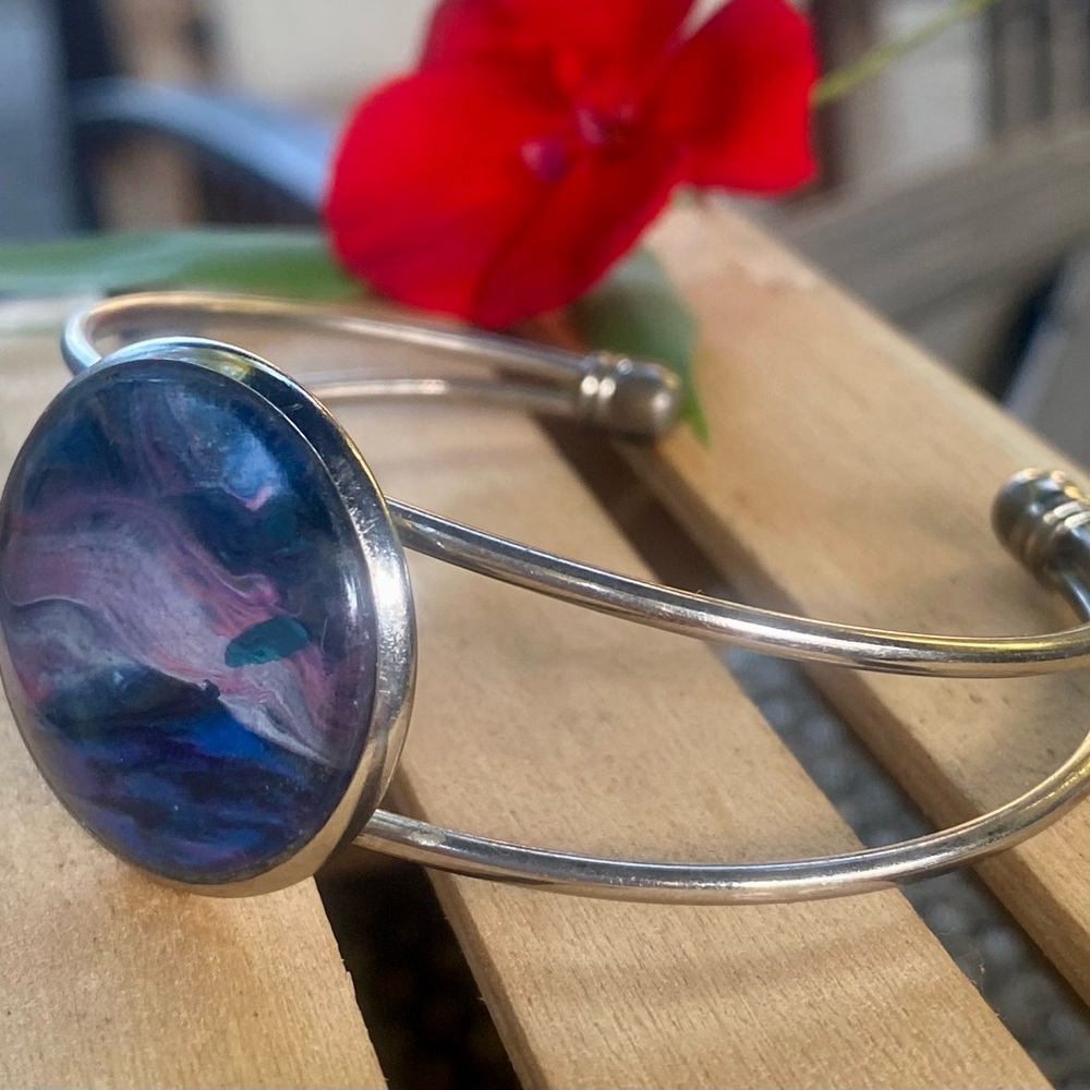 Elegant Silver Cuff Bracelet with Blue and Pink Swirl Design